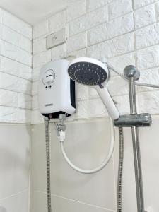 a blow dryer in a shower in a bathroom at The Luna's at Wind Residences in Kaybagal