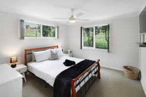 a bedroom with a bed and two windows at Dawn Retreat in Bonnie Doon