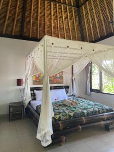 - une chambre avec un lit à baldaquin dans l'établissement Bali Dream House, à Amed