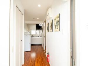 a kitchen with white walls and a hard wood floor at Matsufuji 4F 401 or 402 in Naha