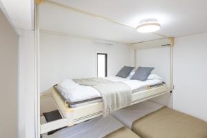 Una cama o camas en una habitación de メゾンドミナ103号室