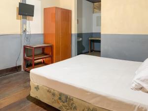a bedroom with a bed and a nightstand and a bed sidx sidx at Pesona Pondok Lembang Mitra RedDoorz in Cikidang 1