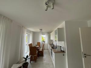 eine Küche und ein Esszimmer mit Tisch und Stühlen in der Unterkunft Ferienwohnung Harms, 85116 in Ostrhauderfehn