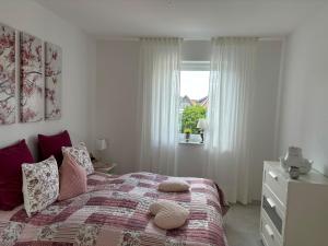 ein Schlafzimmer mit einem Bett mit Kissen und einem Fenster in der Unterkunft Ferienwohnung Harms, 85116 in Ostrhauderfehn