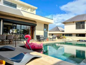 une maison avec une piscine avec un gonflable rose dans l'établissement Villa Rizo de luxe, à Flic-en-Flac