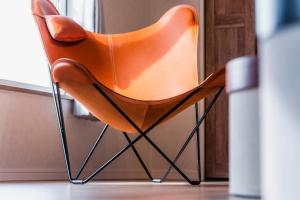 an orange chair sitting in front of a door at 5分車程札幌中心大通公園 豐平川河景四房 廁所x2 浴室x1 淋浴x1 包棟別墅近地鐵 停兩台車 in Sapporo