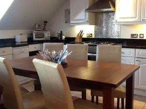 a kitchen with a wooden table and white cabinets at Isle of Wight Seaview in Shanklin