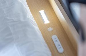 a close up of a remote control next to a bed at 5分車程札幌中心大通公園 豐平川河景四房 廁所x2 浴室x1 淋浴x1 包棟別墅近地鐵 停兩台車 in Sapporo