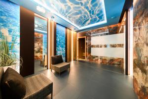 ein Aquarium in einem Hotelzimmer mit einer Couch und einem Sessel in der Unterkunft Ośrodek Wypoczynkowo-Rehabilitacyjny "Bryza" in Dźwirzyno