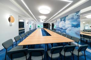 ein Konferenzraum mit einem langen Tisch und Stühlen in der Unterkunft Ośrodek Wypoczynkowo-Rehabilitacyjny "Bryza" in Dźwirzyno