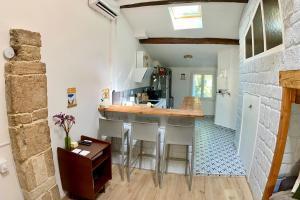 a kitchen with white walls and a bar with stools at T2 Pertica Montpellier Centre ville proche Corum in Montpellier