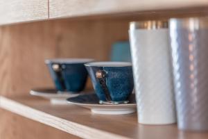 two blue cups and plates on a shelf at 5分車程札幌中心大通公園 豐平川河景四房 廁所x2 浴室x1 淋浴x1 包棟別墅近地鐵 停兩台車 in Sapporo