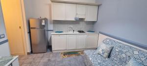 cocina con sofá, fregadero y nevera en La casa del borgo, en Santa Maria del Focallo 2 fotos más
