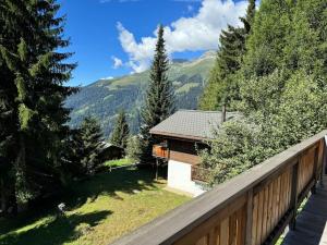 a house in the mountains with a wooden fence at Chalet Glücksfall in Bellwald