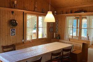 a dining room with a table and some windows at Chalet Glücksfall in Bellwald