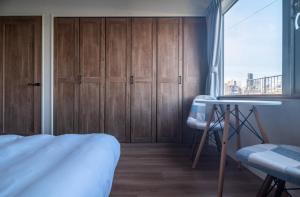 a bedroom with wooden cabinets and a bed and a window at 5分車程札幌中心大通公園 豐平川河景四房 廁所x2 浴室x1 淋浴x1 包棟別墅近地鐵 停兩台車 in Sapporo