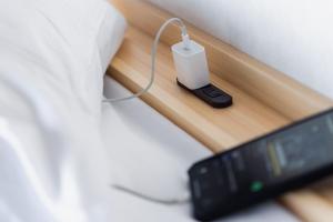 a remote control sitting on a table next to a bed at 5分車程札幌中心大通公園 豐平川河景四房 廁所x2 浴室x1 淋浴x1 包棟別墅近地鐵 停兩台車 in Sapporo