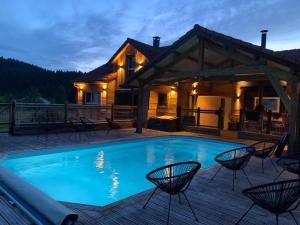 a house with a swimming pool on a deck at Chalet Les Prés Chaussottes in Gérardmer