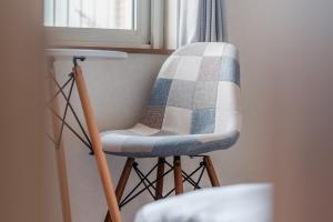 a chair sitting next to a window with a blanket on it at 5分車程札幌中心大通公園 豐平川河景四房 廁所x2 浴室x1 淋浴x1 包棟別墅近地鐵 停兩台車 in Sapporo