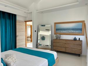 - une chambre avec un lit, une fenêtre et une commode dans l'établissement Villa Rizo de luxe, à Flic-en-Flac