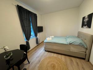 a small bedroom with a bed and a table at City Ferien Wohnungen 3 in Rosenheim