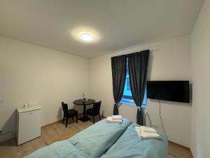 a bedroom with a bed and a table with chairs at City Ferien Wohnungen 3 in Rosenheim