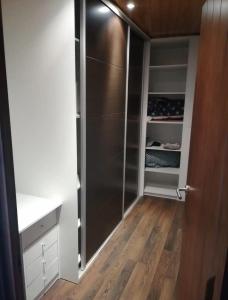 a walk in closet with a stainless steel refrigerator at Casa de encanto in Villanueva de Arosa