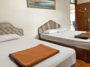 two beds in a room with two beds sidx sidx sidx sidx at Cozy Homestay Syariah Mitra RedDoorz Bandung in Bandung