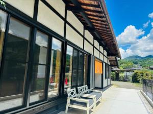 a porch with two white benches on a building at かきぞれ大黒宿ー1日1組限定 築120年の古民家と貸切サウナ完備 in Nakakiri