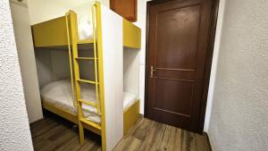 a small room with a bunk bed and a door at Hostdomus - Yellow Suite in Sestriere