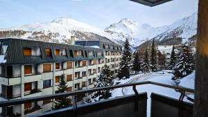 a view from a balcony of a building with snow covered mountains at Hostdomus - Yellow Suite in Sestriere