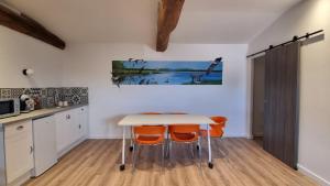 a kitchen with a table and some orange chairs at Art et cosy in Savigneux