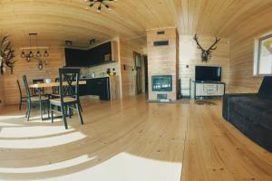 a living room with a table and chairs and a kitchen at Domek Apartament Windyki in Iława