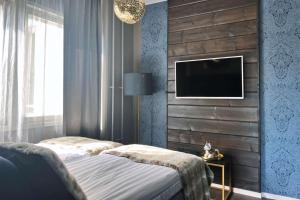 a bedroom with a bed and a tv on a wall at Hotel Golden Circle Suites in Rovaniemi