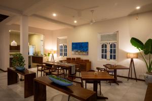 Un comedor con mesas y sillas y una cocina. en On The Rocks, en Unawatuna