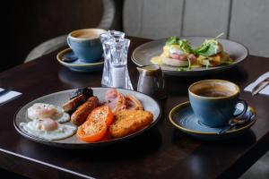 a table with two plates of food and a cup of coffee at Glashaus Hotel in Tallaght