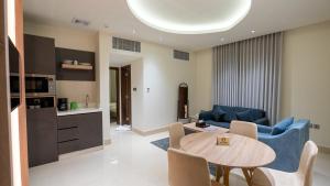 a living room with a table and a kitchen at Maskan Alolya Serviced Apartment in Al Khobar