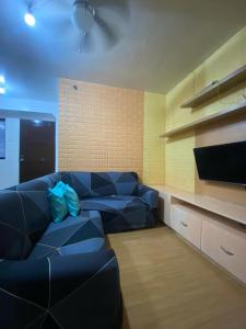 a living room with a blue couch and a tv at comfy Deca homes hernan cortes near sm jmall in Mandaue City