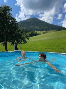 two people in a swimming pool in a field at Wimmhof in Sankt Martin am Tennengebirge