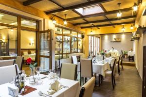 un comedor con mesas y sillas blancas en Best Western Plus Bristol Hotel, en Sofía
