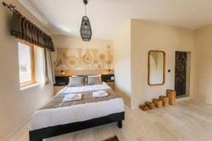ギョレメにあるCappadocia Aishe Hotelの大きなベッドと鏡のある寝室