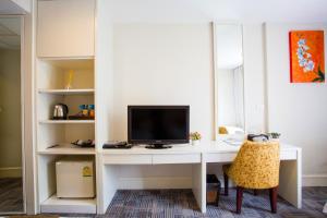a white desk with a tv on top of it at Aphrodite Inn Bangkok in Bangkok