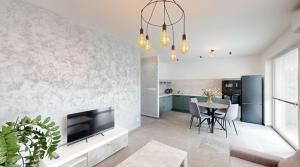 Una sala de estar con un televisor y una mesa con sillas. en SALAN Apartman Sereď, en Seredʼ