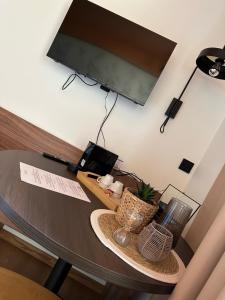 a room with a table with a television on a wall at La Différence in Vichten
