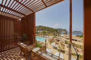 a balcony with a view of the beach and the ocean at Cala San Miguel Ibiza Resort, Adults only, Curio Collection by Hilton in Puerto de San Miguel
