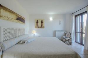 Un dormitorio blanco con una cama grande y una silla. en Agriturismo il Montoto - Nature & Relax, en Castiglione della Pescaia