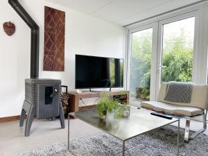 a living room with a fireplace and a tv at Bungalow 77 op Recreatiepark De Wielen in Sint Maarten