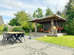 a patio with a table and a gazebo at Bungalow 77 op Recreatiepark De Wielen in Sint Maarten