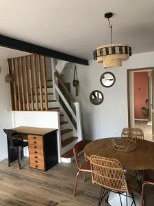 a dining room with a table and chairs and stairs at La loc donvillaise in Donville-les-Bains