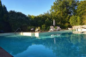 a swimming pool with chairs and an umbrella on a boat at Elégance Périgourdine and SPA in Sainte-Sabine